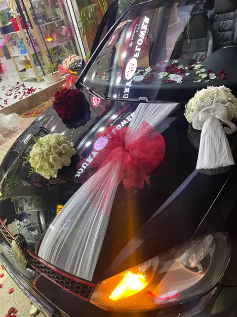 Rubans blancs et nœuds rouges sur voiture de mariage à Tetouan